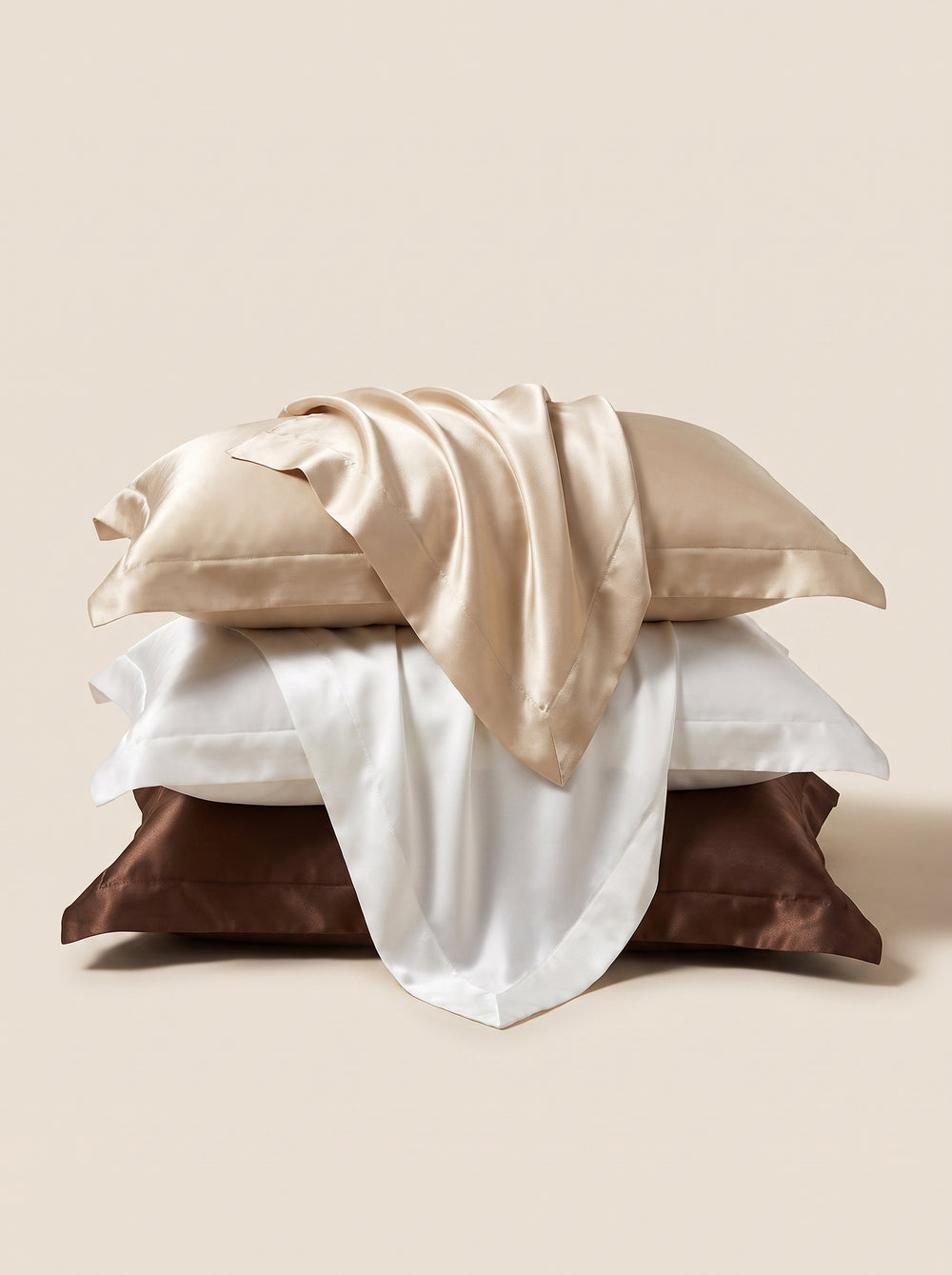 Set di federe in seta color champagne, bianco e marrone cioccolato, con lucentezza setosa